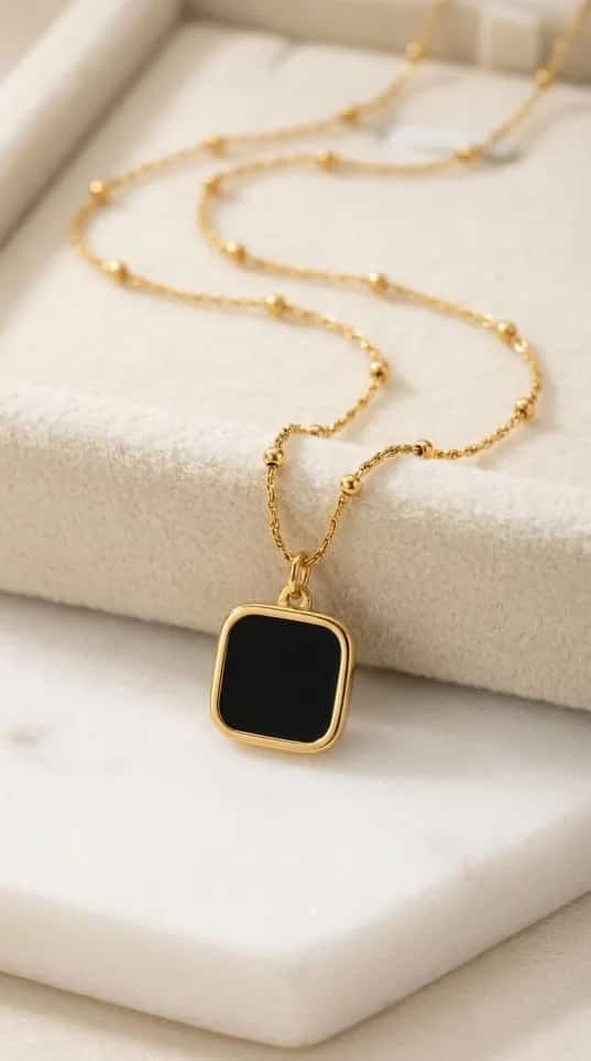 Gold satellite chain necklace with a black enamel square pendant