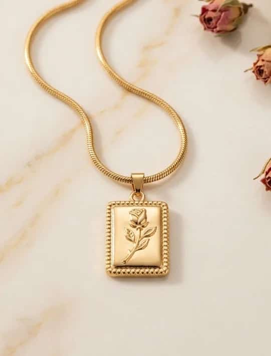 Gold necklace with a rectangular engraved tag pendant on a fine chain